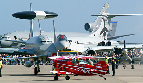 Tornado GR.4 pilot Richard Pargeter in his Pitts Special G-PARG taxies back across a ramp full of current military hardware after displaying	