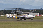 DH 115 Vampire with hovering UH-1H in the background