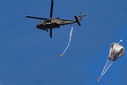 Some parachutists jumping from a 1st CAB UH-60M over Maniago range